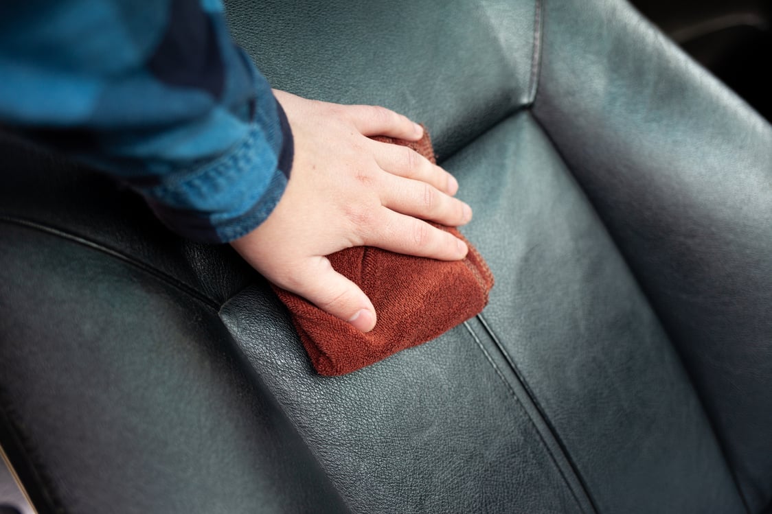 Hand Wiping the Leather Car Seat 