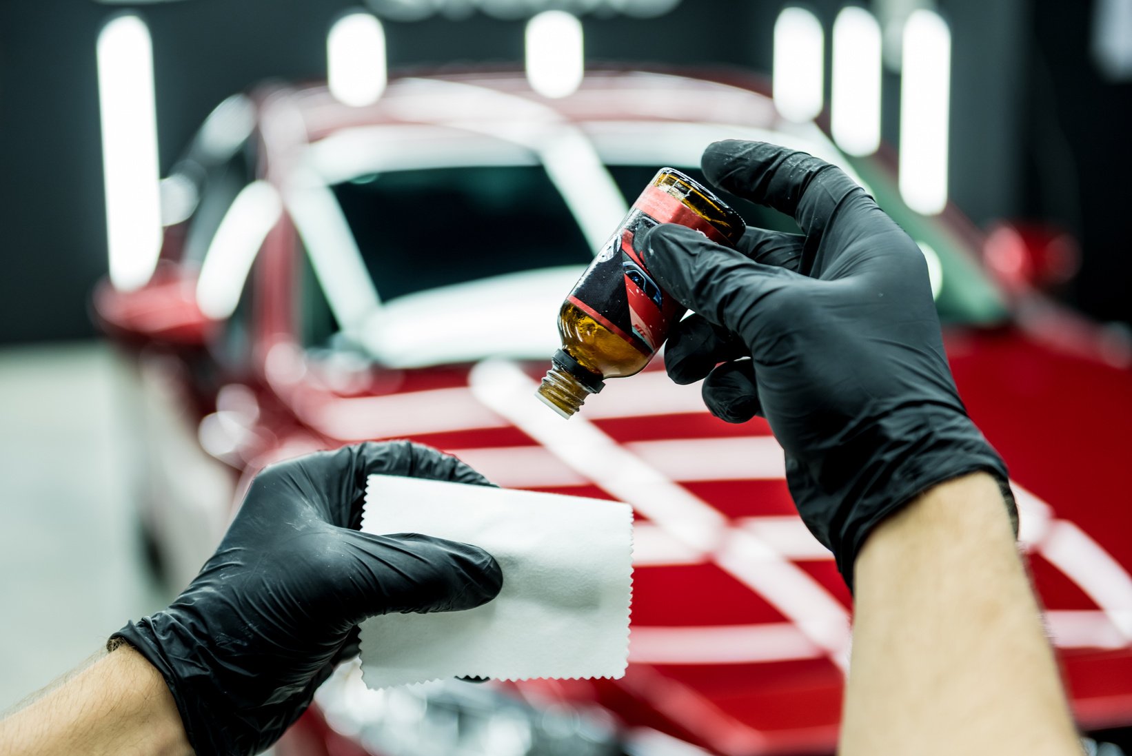 Car service worker applying nano coating on a car detail.